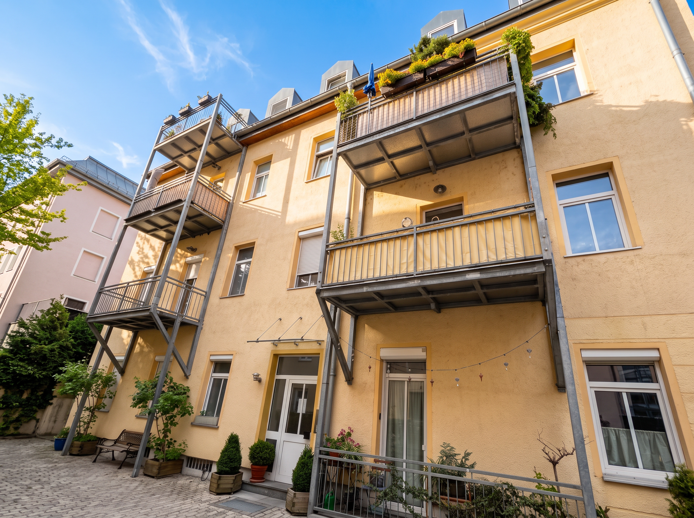 Sonnige Hofansicht des Wohnhauses in der Senserstraße in München-Sendling mit Balkonen