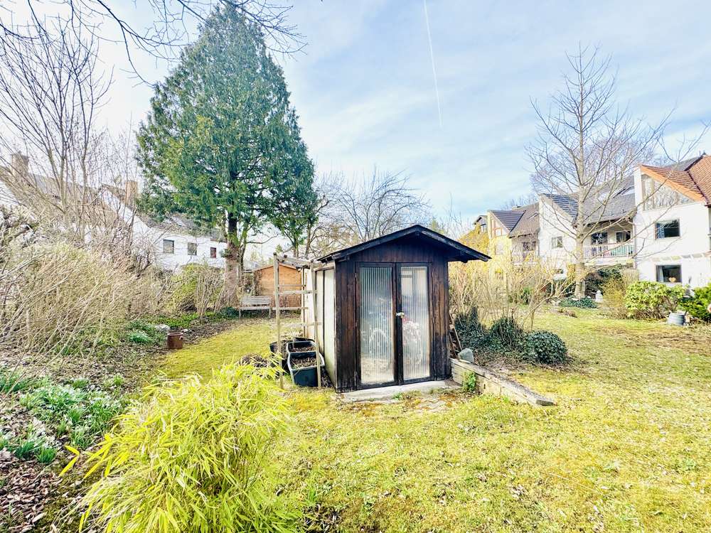 Sonniger Garten mit Rasenfläche und Gartenhaus des Reiheneckhauses in Gröbenzell-Süd